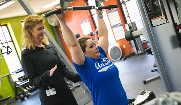 A personal trainer works with a student in the Gym