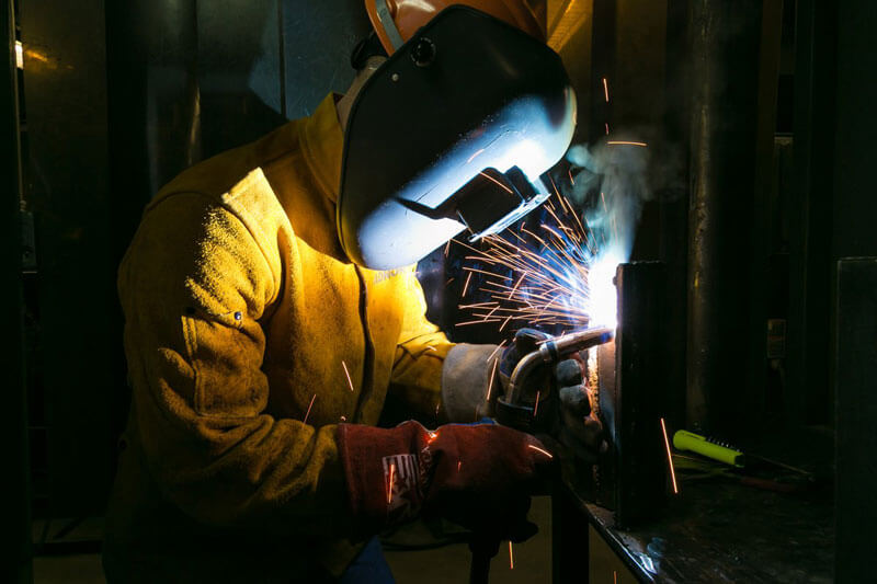 A student wears a protective mask while welding